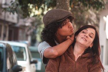 Düğün çifti sokakta sarılıyor.