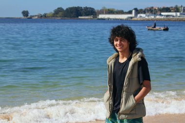 Genç adam sahilde yürüyor.