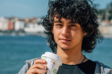 Genç bir adam kıyı şeridi geçmişine sahip bir paket servisi tutuyor.