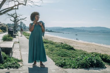 Dışarıda cep telefonuyla konuşan genç bir kadın.