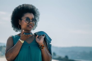 Genç bir kadın dışarıda cep telefonuyla mesaj ya da ses gönderiyor.