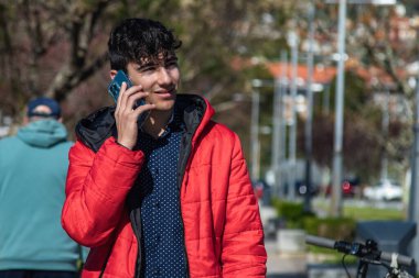 Sokakta akıllı telefon kullanan genç bir şehirli.