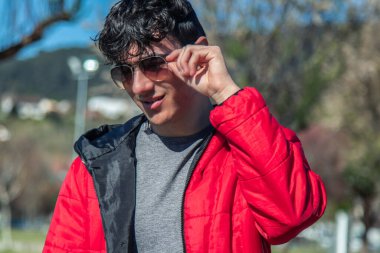 Sokakta güneş gözlüğü takan yakışıklı bir genç.