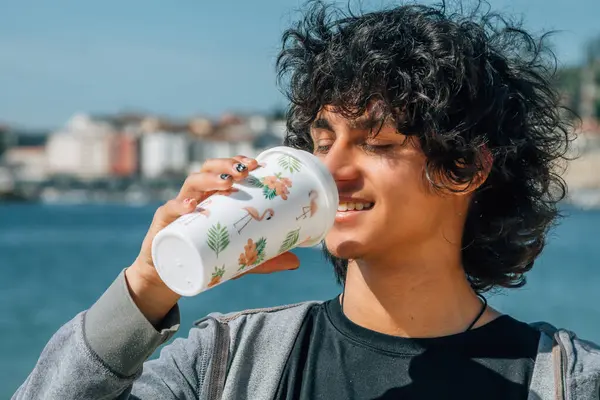 Genç adam bir fincan sıcak kahve içiyor.