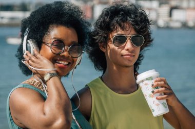 Çiftler sahilde eğleniyor ve meşrubat içiyor.