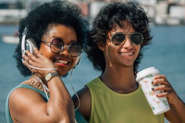 Çiftler sahilde eğleniyor ve meşrubat içiyor.