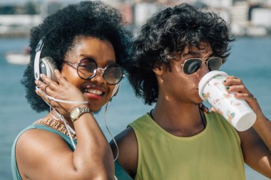 Çiftler sahilde eğleniyor ve meşrubat içiyor.