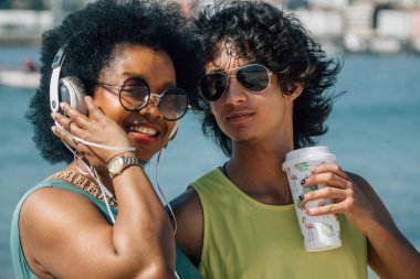 Çiftler sahilde eğleniyor ve meşrubat içiyor.