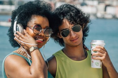 Çiftler sahilde eğleniyor ve meşrubat içiyor.