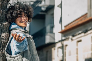 Şehirde kolları havada rahat genç bir adam.