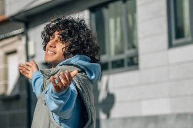 Şehirde kolları havada rahat genç bir adam.