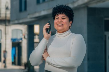 Sokakta cep telefonuyla konuşan orta yaşlı bir kadın.