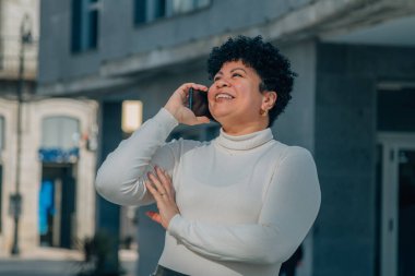 Sokakta cep telefonuyla konuşan orta yaşlı bir kadın.