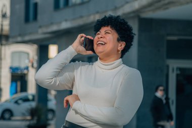 Sokakta cep telefonuyla konuşan orta yaşlı bir kadın.
