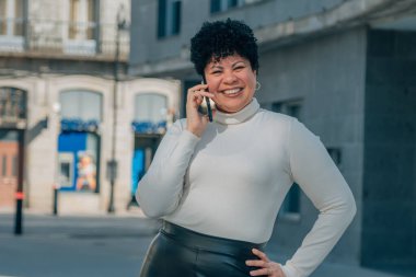 Sokakta cep telefonuyla konuşan orta yaşlı bir kadın.