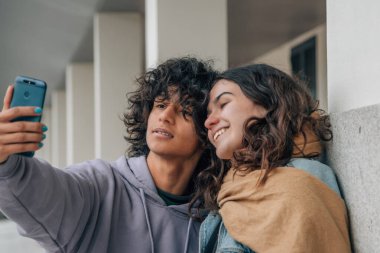 Genç bir çift selfie çekiyor ya da sokakta canlı video çekiyor.