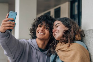 Genç bir çift selfie çekiyor ya da sokakta canlı video çekiyor.