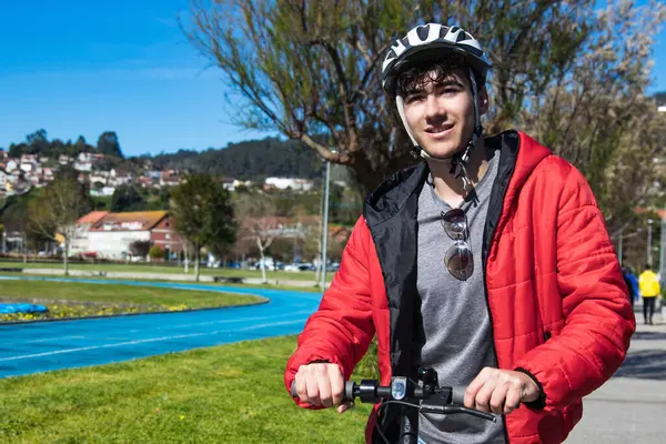 Sokakta elektrikli scooter kullanan genç adam.