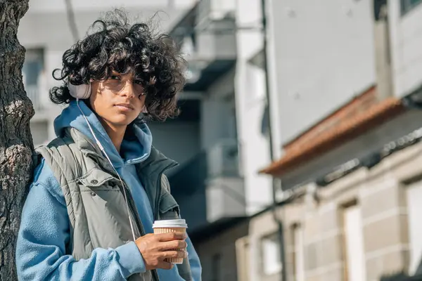 Kulaklıklı ve sokakta yemek servisi yapan Latin kökenli genç bir adam.