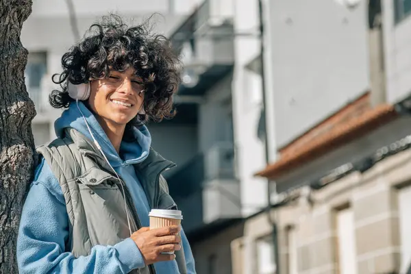 Kulaklıklı ve sokakta yemek servisi yapan Latin kökenli genç bir adam.