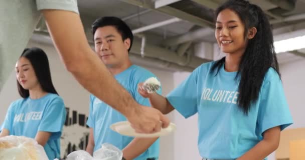 身穿蓝色T恤衫的志愿者为有需要的人提供食物 — 图库视频影像