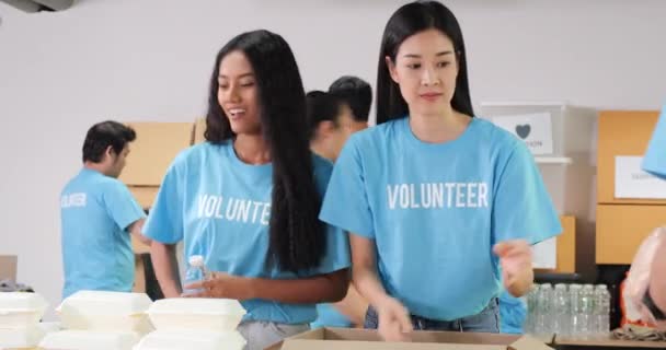 身穿蓝色T恤衫的志愿者为有需要的人提供食物 — 图库视频影像