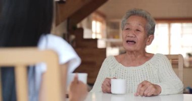 Kıdemli kadın torunuyla evde vakit geçiriyor.