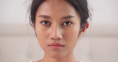 Kameraya bakıp koruyucu maske takan Asyalı bir kadının yakın çekim görüntüleri.