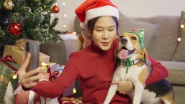 Evde köpeği olan sevimli Asyalı kadın, Noel konsepti.