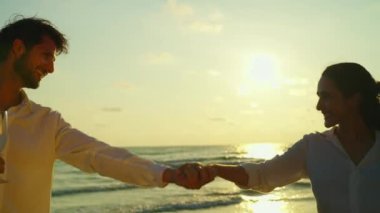 Asırlık bir çiftin sahilde yürürken birbirlerine eşlik etmelerinin görüntüleri.