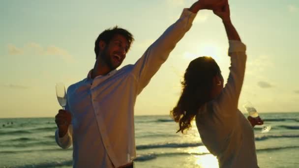 海岸で踊りながらお互いの会社を楽しんでるカップルの映像 — ストック動画