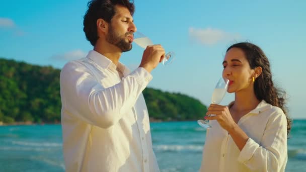 ビーチでシャンパンを飲む幸せと陽気なカップル — ストック動画