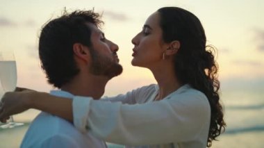 Mutlu ve neşeli bir çift sahilde öpüşüyor.