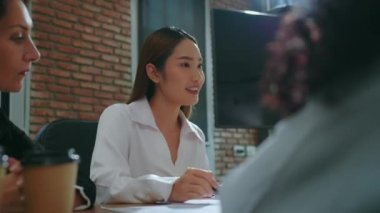 bir grup iş adamı ofiste çalışmayı tartışıyor.