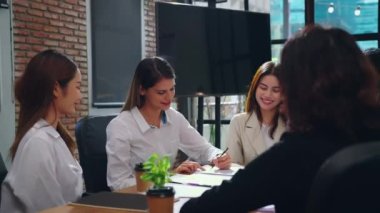 bir grup iş adamı ofiste çalışmayı tartışıyor.
