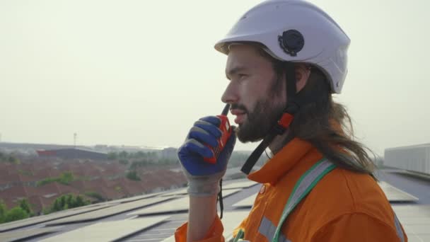 男工头戴硬礼帽 带着对讲机 在大楼屋顶上安装太阳能电池板 — 图库视频影像