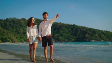 Kumsalda yürüyen mutlu ve neşeli bir çift