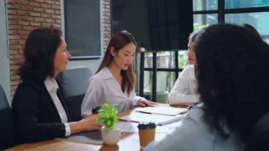 bir grup iş adamı ofiste çalışmayı tartışıyor.