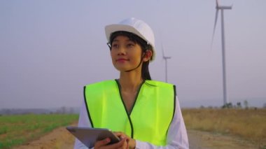 Yel değirmeninin arka planında tabletli beyaz şapkalı güzel bir kadın.