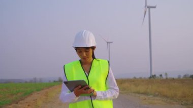 Yel değirmeninin arka planında tabletli beyaz şapkalı güzel bir kadın.