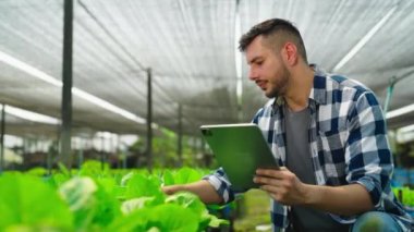 Serada çalışan tabletli genç bahçıvan.  