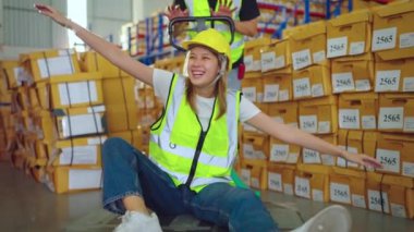 Fabrikada koruyucu üniformalı ve kasklı depo çalışanları var.