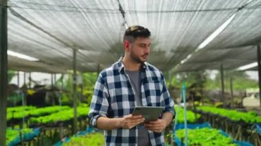 Serada çalışan tabletli genç bahçıvan.  