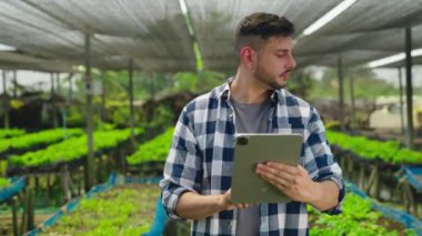Serada çalışan tabletli genç bahçıvan.  