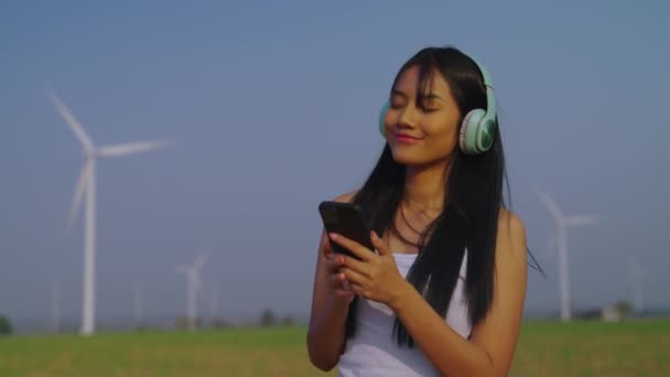Mujer Joven Auriculares Fondo Con Turbinas Eólicas — Vídeo de stock