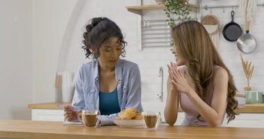 Genç kadınlar mutfakta kahve içiyor.