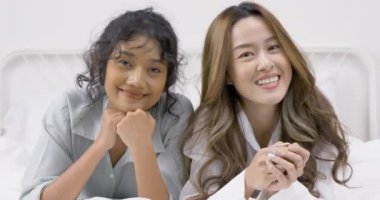 Aşık genç kadınlar odada yatakta yatıyor.