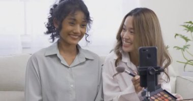 Evde makyaj yapan genç kadınlar.