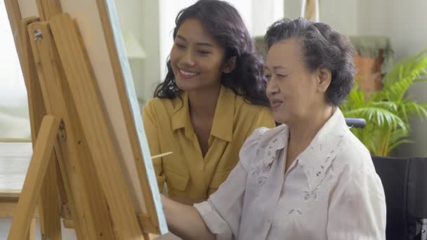 Seniorin Und Enkelin Malen Gemeinsam Ein Bild Hause — Stockvideo