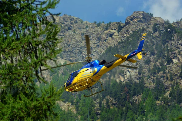 Aosta Vadisi, İtalya 07-18-2022 Bir kargo helikopteri dağ manzarasında uçuyor